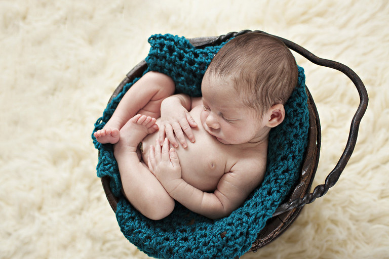 Newborn photo session of boy in bucket