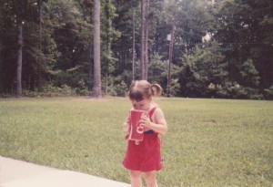 little girl in red drinking a big coke