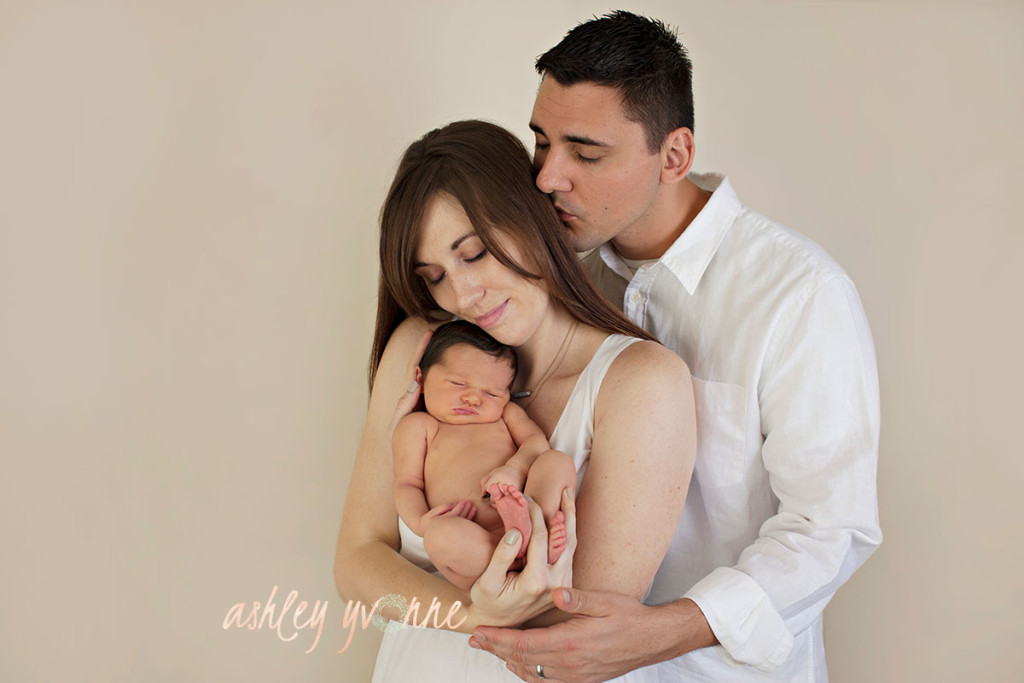 dad mother and newborn girl smiling